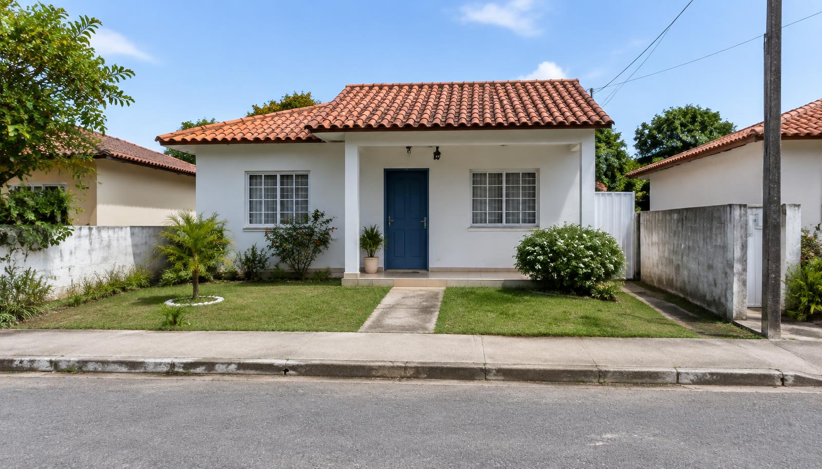 Casa simples com varanda e pequeno jardim